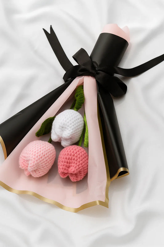 Knitted flowers in a black and gold wrap on a white background